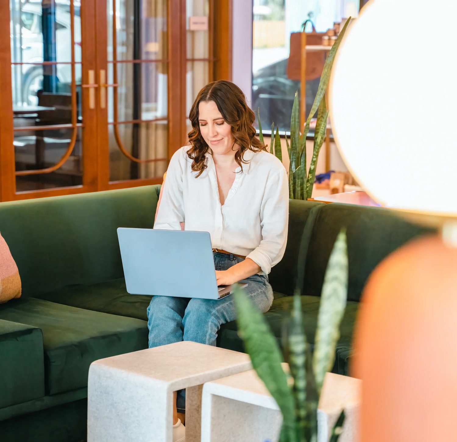 Guest working on a laptop on the green lobby sofa